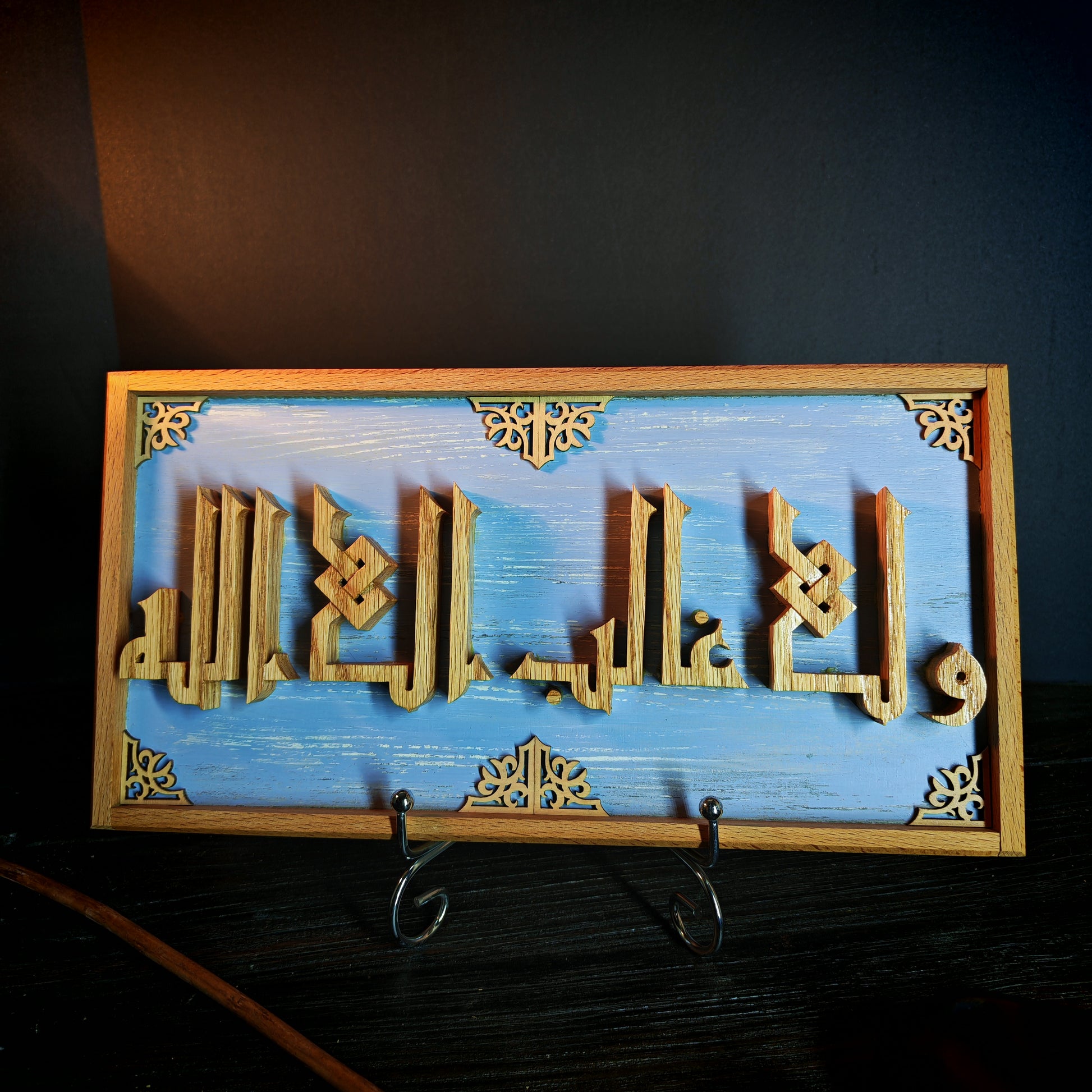 Decorative wall art with Arabic calligraphy on a blue background